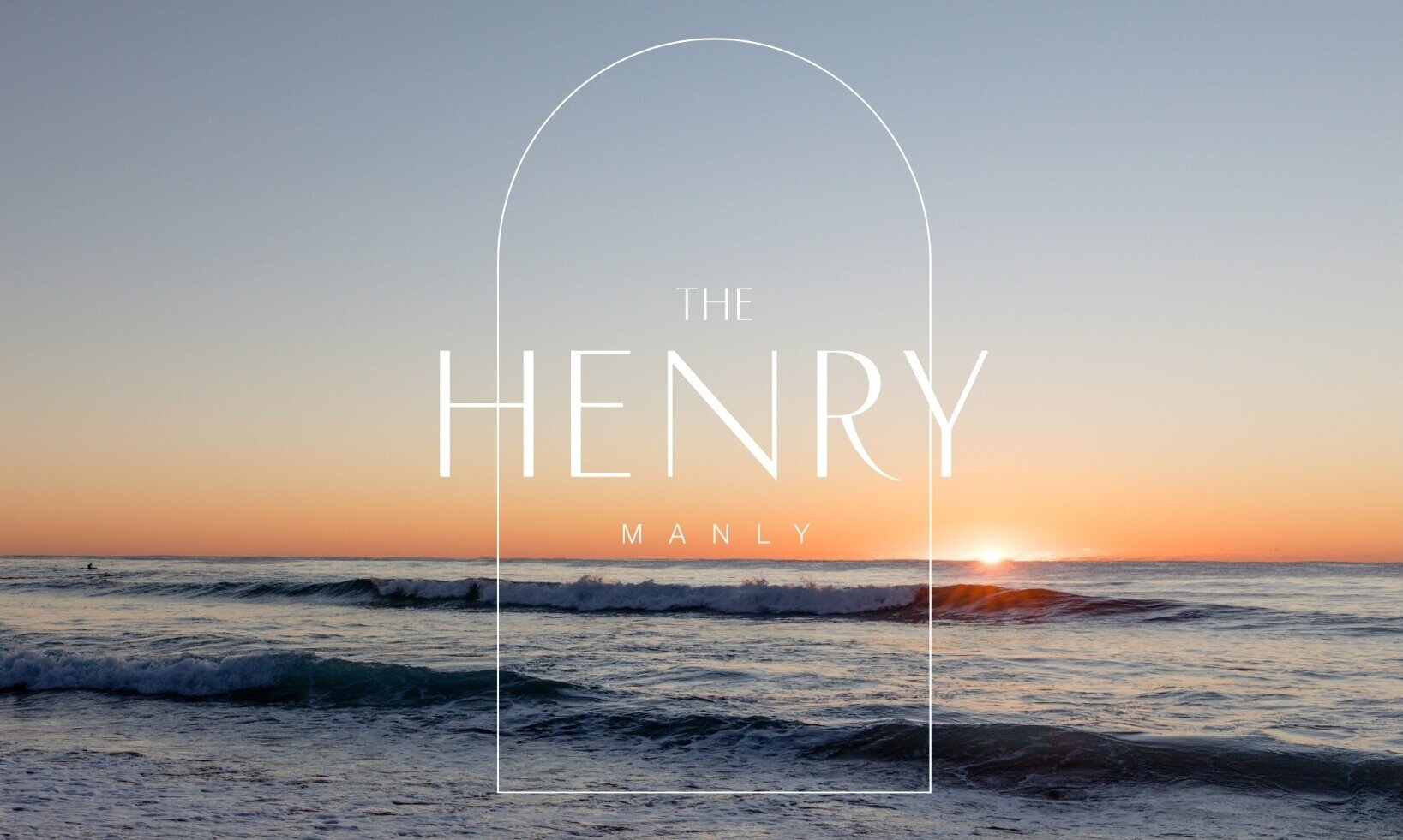The Henry Manly — sunset ocean view with logo