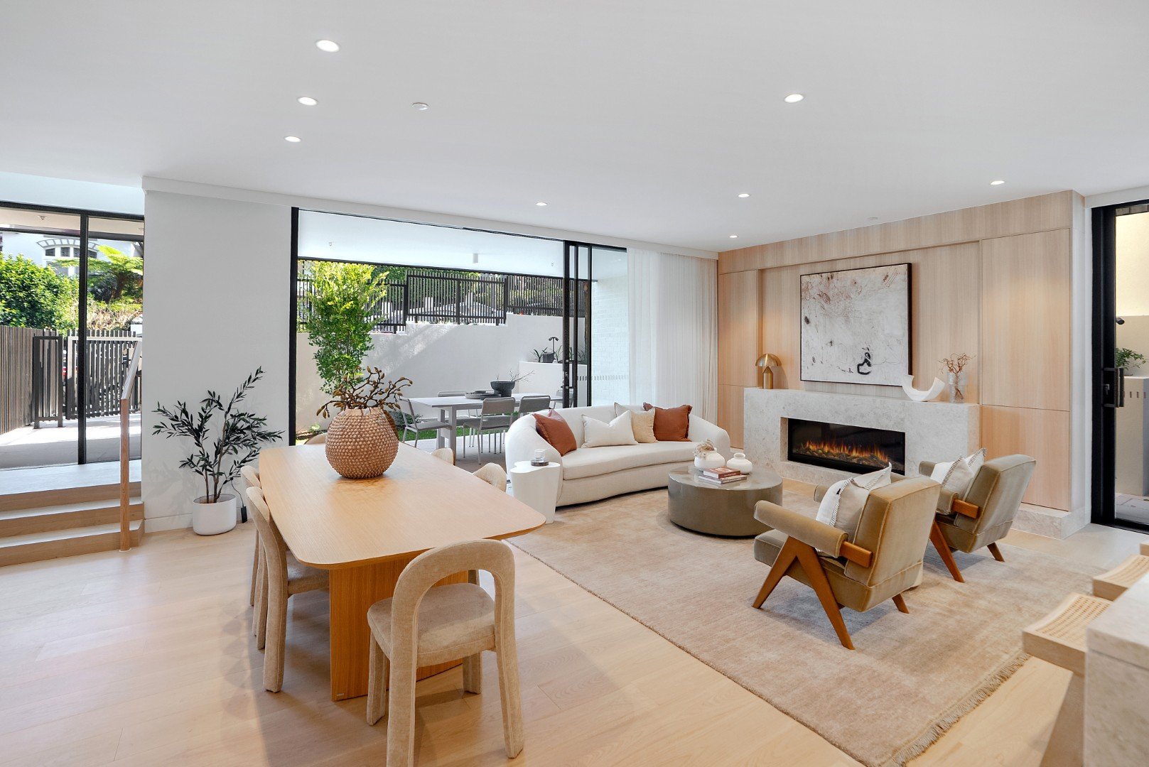 The Henry Manly open-plan living area with oak flooring, gas fireplace and outdoor kitchen